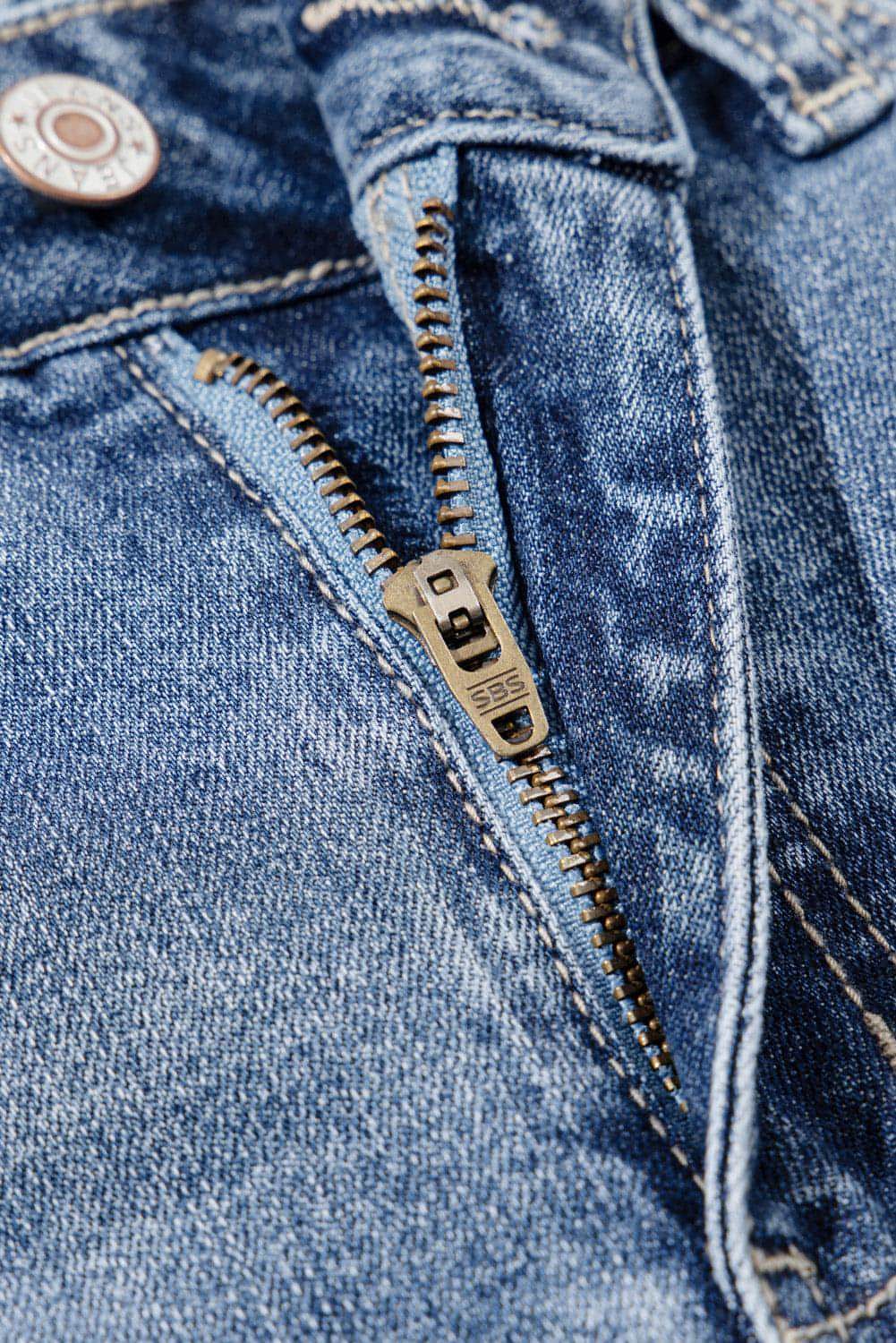 Dusk blue high-rise ripped distressed hem flared jeans by Carmine Juneberry, showing front view with ripped details and flared legs.