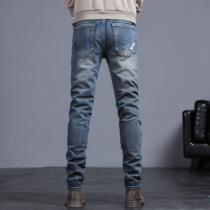 Youth retro embroidered denim pants for men by Carmine Juneberry, featuring classic blue jeans with colorful embroidered details.