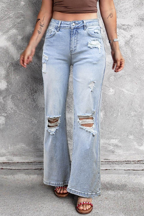 Carmine Juneberry Beau Blue vintage light wash distressed flare jeans hanging on a rack with frayed edges and faded denim.