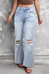Carmine Juneberry Beau Blue vintage light wash distressed flare jeans hanging on a rack with frayed edges and faded denim.