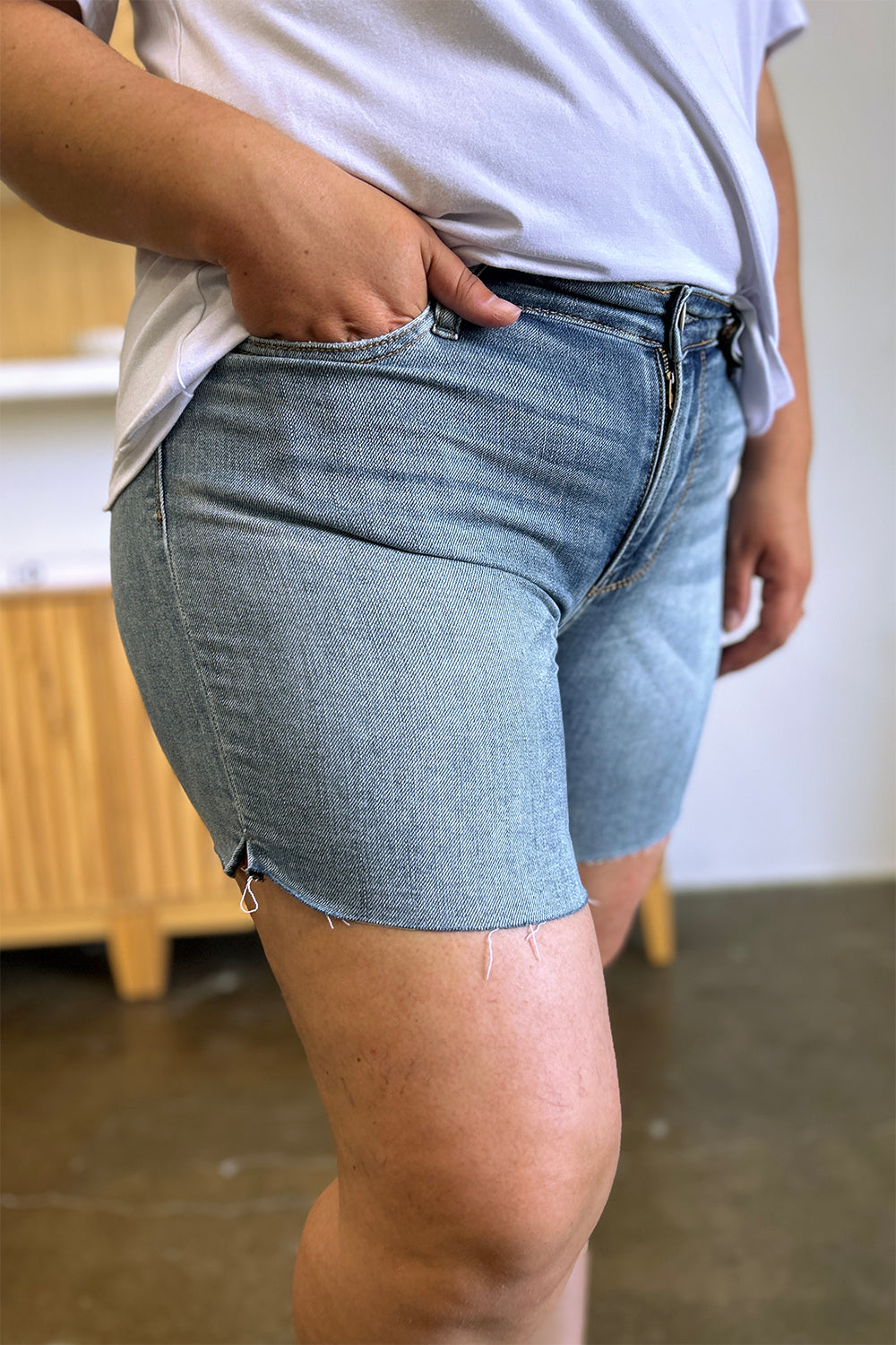 Judy Blue high waist raw hem denim shorts with distressed details, styled for a casual look, by Jade Icarus