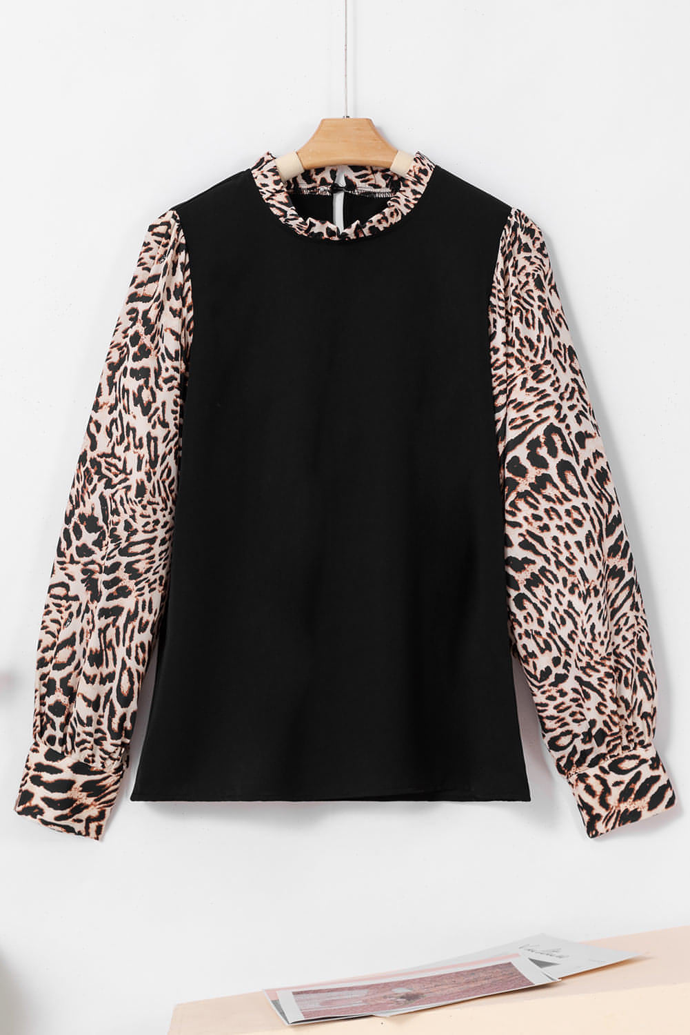 Black contrast leopard print lantern sleeve blouse by Carmine Juneberry, showcasing stylish long-sleeve top with bold animal pattern.