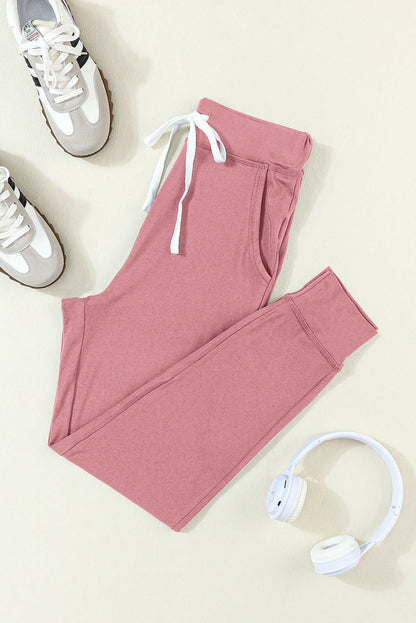 Pink drawstring waist joggers with side pockets, Carmine Juneberry activewear pants for comfortable exercise and casual wear.