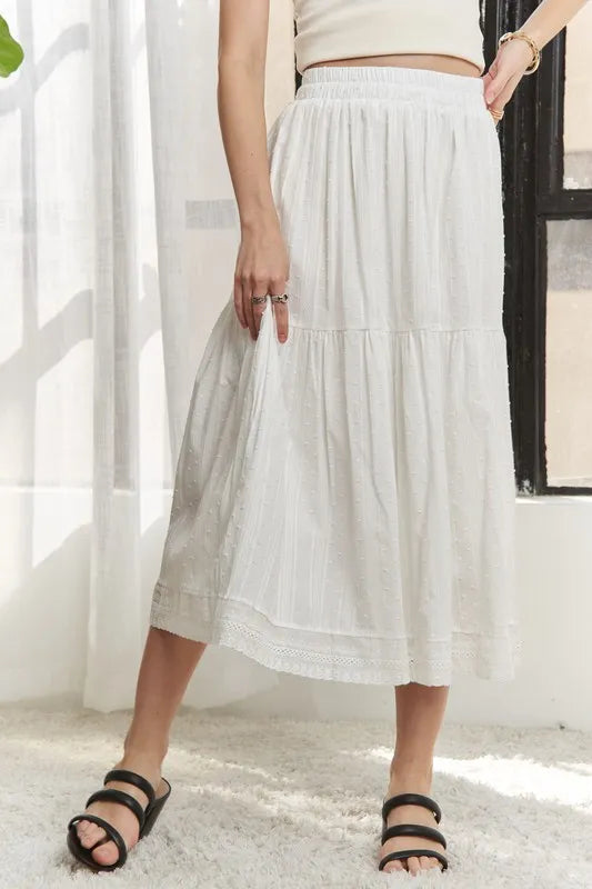 Jade Icarus ADORA elastic waistband tiered midi skirt, displayed in a fashion photo showcasing its flowy design and fabric details.