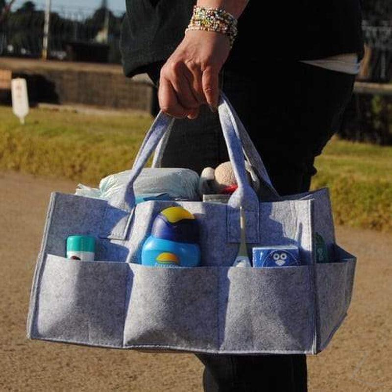 Grey felt nappy organizer caddy by Raspberry Pallas with multiple compartments for baby essentials and diaper organization.