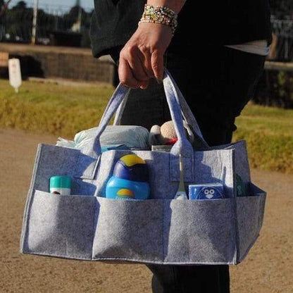 Grey felt nappy organizer caddy by Raspberry Pallas with multiple compartments for baby essentials and diaper organization.