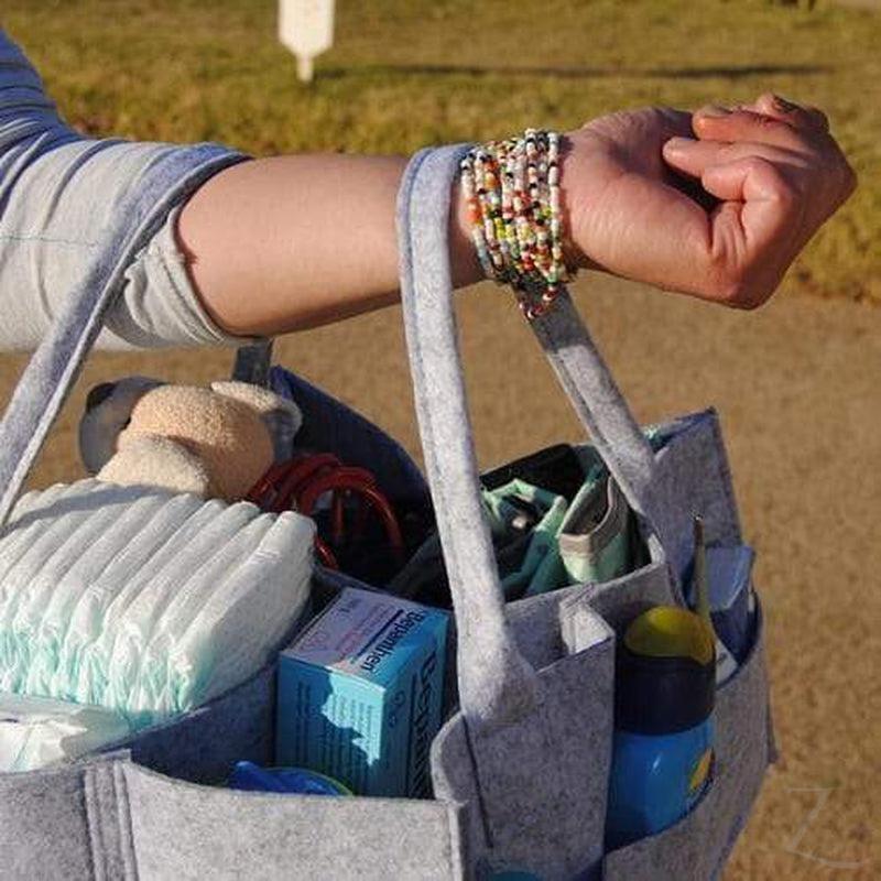 Grey felt nappy organizer caddy by Raspberry Pallas with multiple compartments for baby essentials and diaper storage.