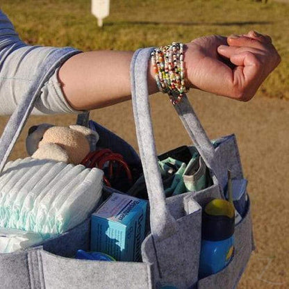 Grey felt nappy organizer caddy by Raspberry Pallas with multiple compartments for baby essentials and diaper storage.