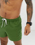 Forest green swim shorts by Sky Felix, displayed flat with elastic waistband and side pockets, suitable for beach or poolwear.