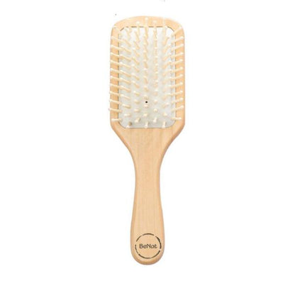 Natural wooden detangling hair brush by Jade Chrysippus, designed for gentle hair care in the bathroom.