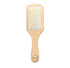 Natural wooden detangling hair brush by Jade Chrysippus, designed for gentle hair care in the bathroom.