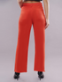 Women’s high rise orange denim jeans by Ochre Ourea, displayed on a hanger with visible stitching and classic five-pocket style.