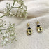 A pair of gold Keya Flower earrings by Ariel featuring floral design and intricate craftsmanship.