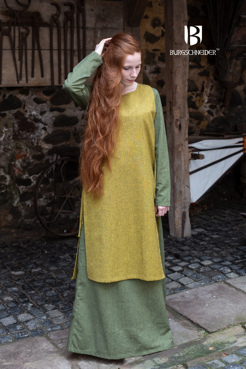 Azure Briseis Over Dress Haithabu in saffron yellow, perfect for festivals and parties, shown on a model against a festive backdrop.