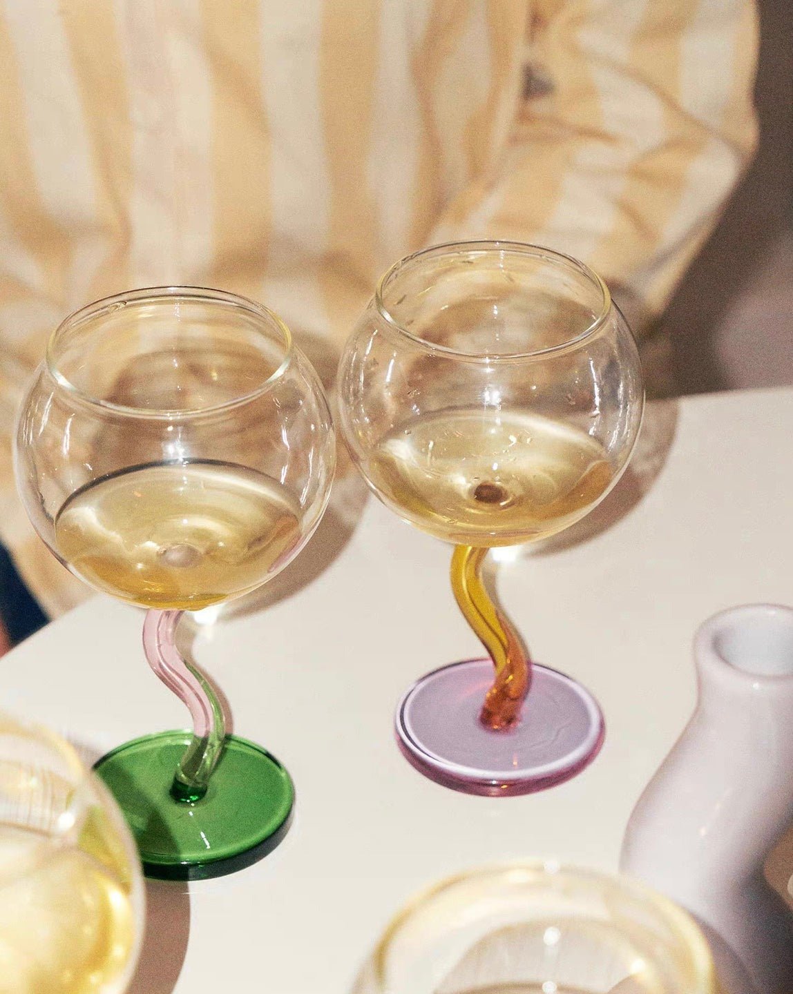 Handblown bubble wine glass with a retro wavy stem in burgundy, featuring a whimsical, eclectic design for home decor.