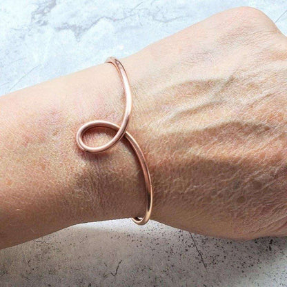 Handmade sculpted copper teardrop bangle bracelet by Blue Crius, featuring detailed craftsmanship and a smooth, polished finish.