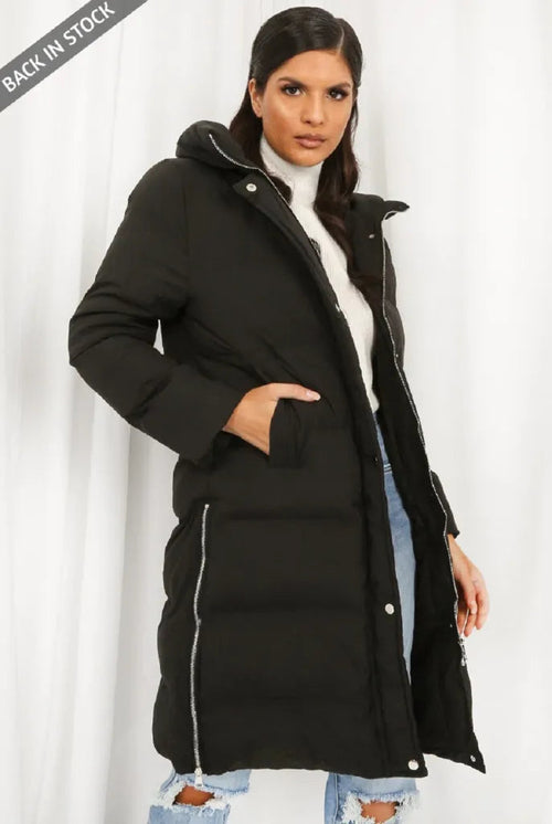 Black hooded longline puffer coat by Rose Eleusis, stylish outerwear with a cozy, insulated design and a modern silhouette.