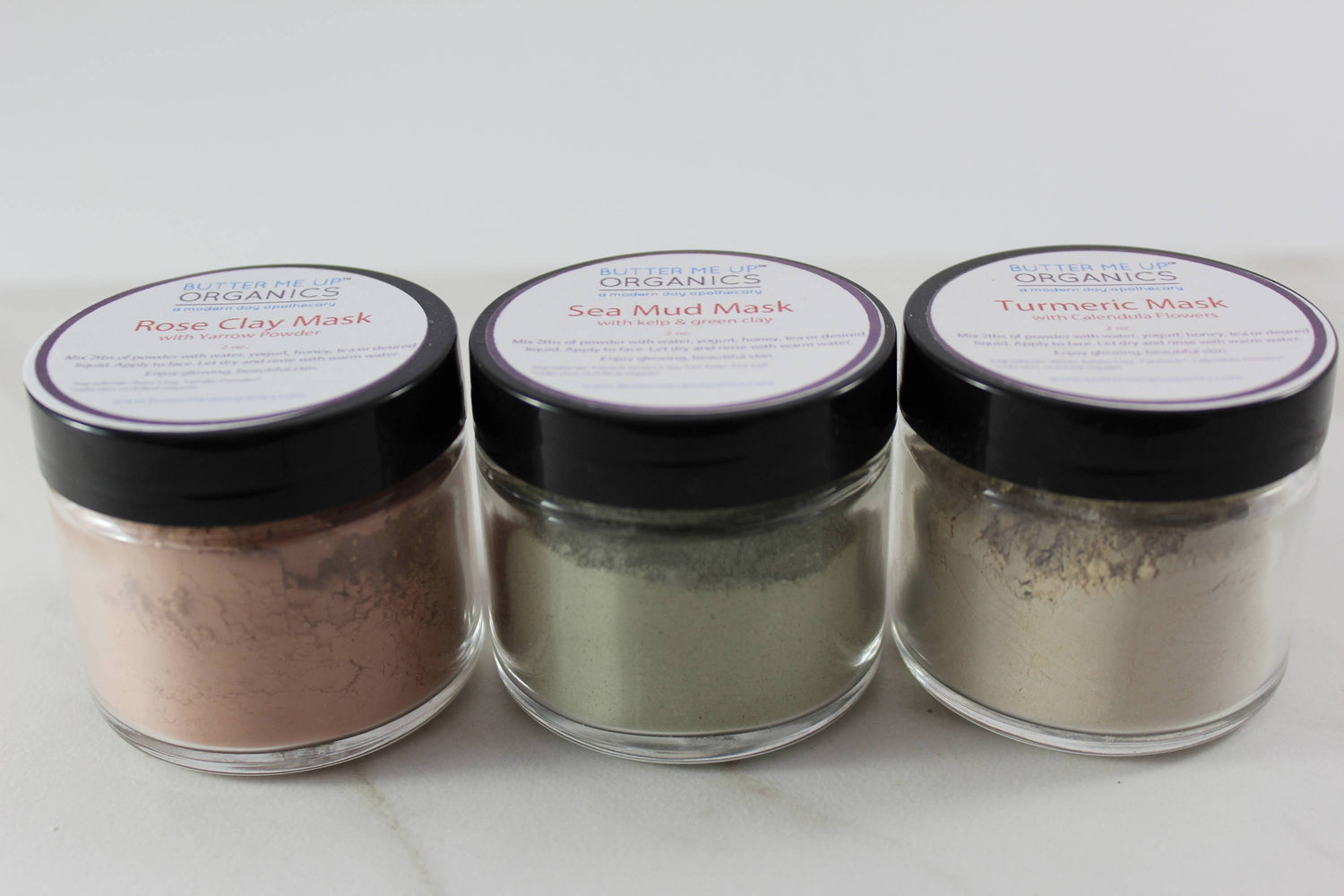 White Smokey clay face mask trio featuring rose, French green, and kaolin clay with turmeric, displayed in white bowls.
