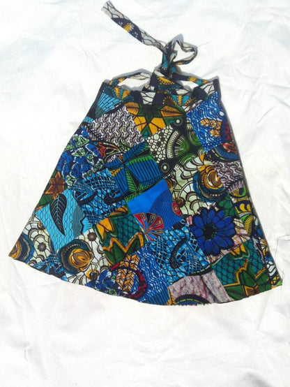 White Baobab Kitenge round women mini wrap skirt with vibrant African print fabric, styled with a tied waist and flowing hem.