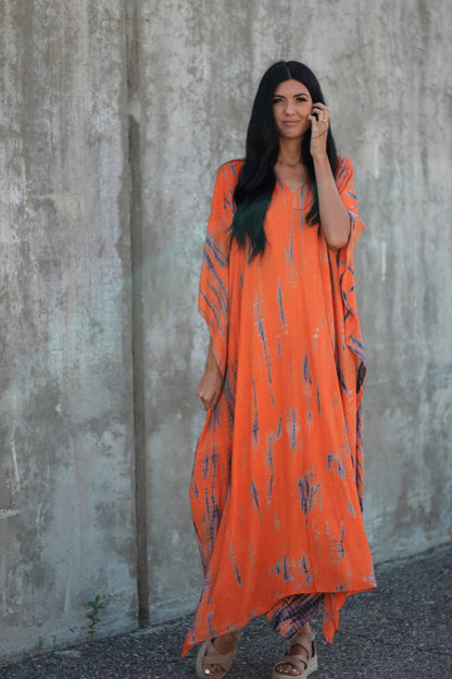 Hand-dyed orange tie-dye maxi kaftan dress with pockets by Erin Pontus, loose fit, flowing fabric, perfect for casual or beachwear.