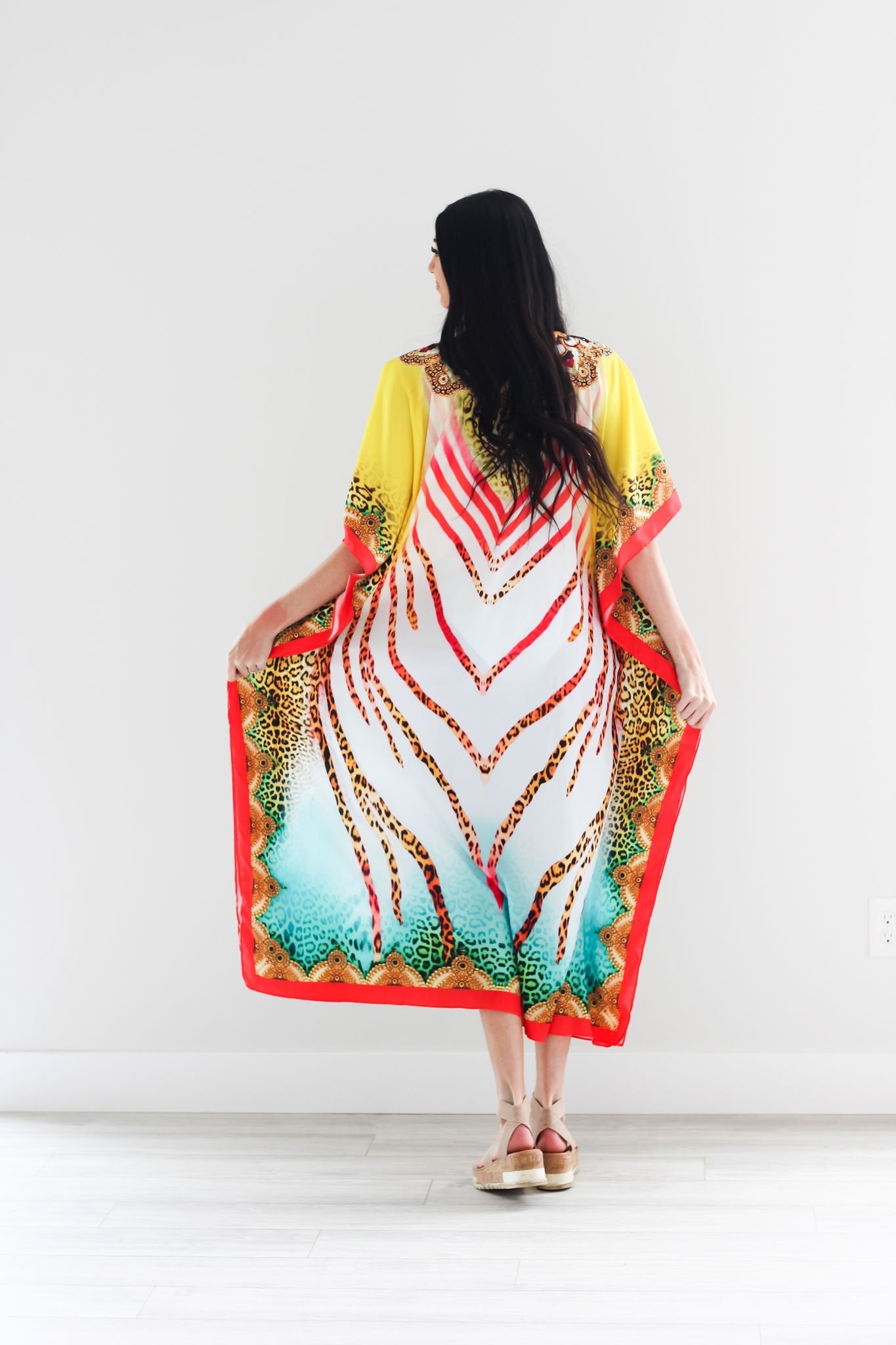 Traditional tribal African kaftan dress by Erin Pontus featuring vibrant patterns and flowing fabric, perfect for casual or cultural wear.
