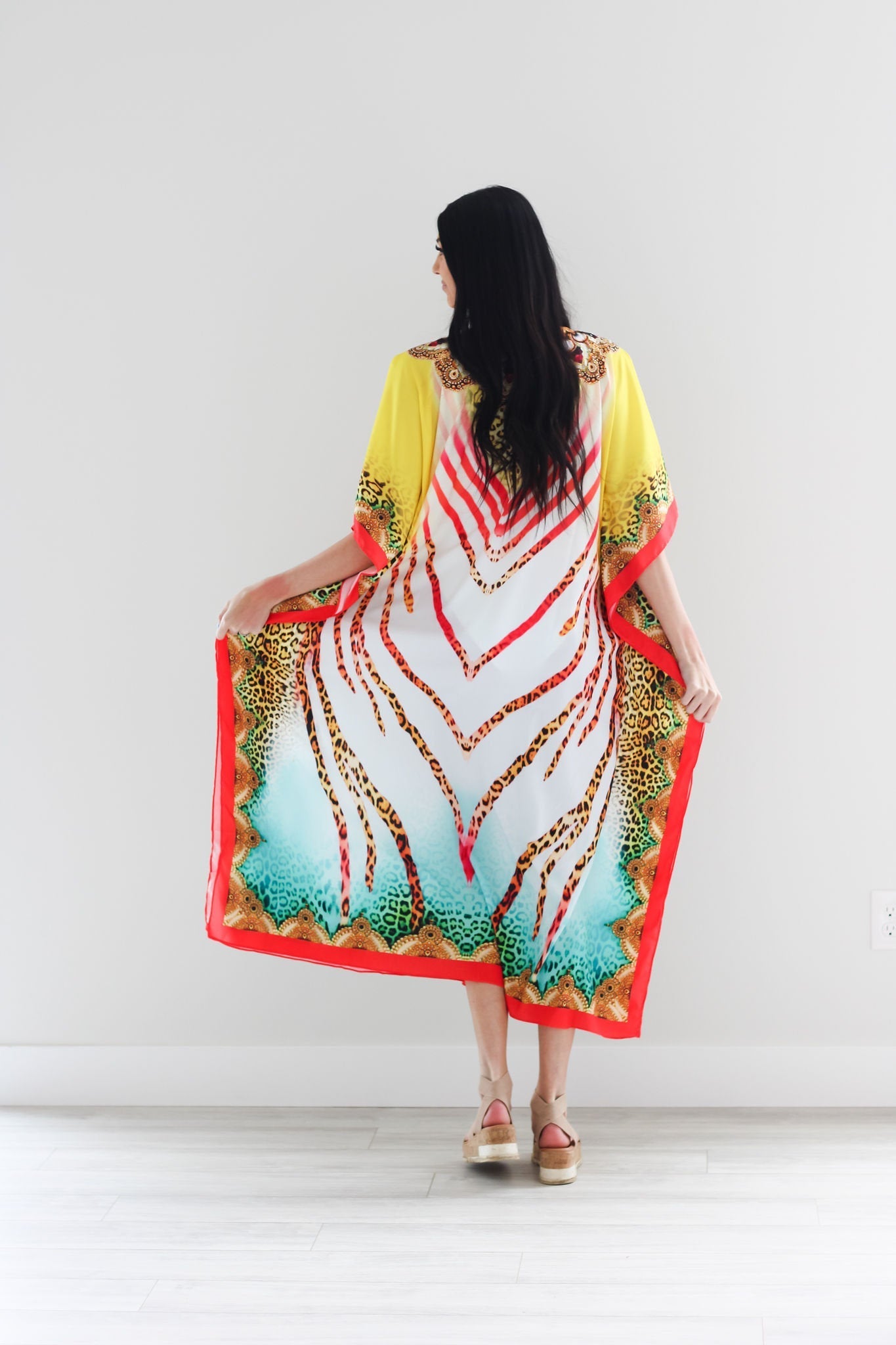 Traditional African tribal kaftan dress by Erin Pontus featuring vibrant patterns and flowing fabric, perfect for elegant occasions.