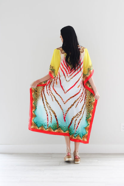 Traditional African tribal kaftan dress by Erin Pontus featuring vibrant patterns and flowing fabric, perfect for elegant occasions.