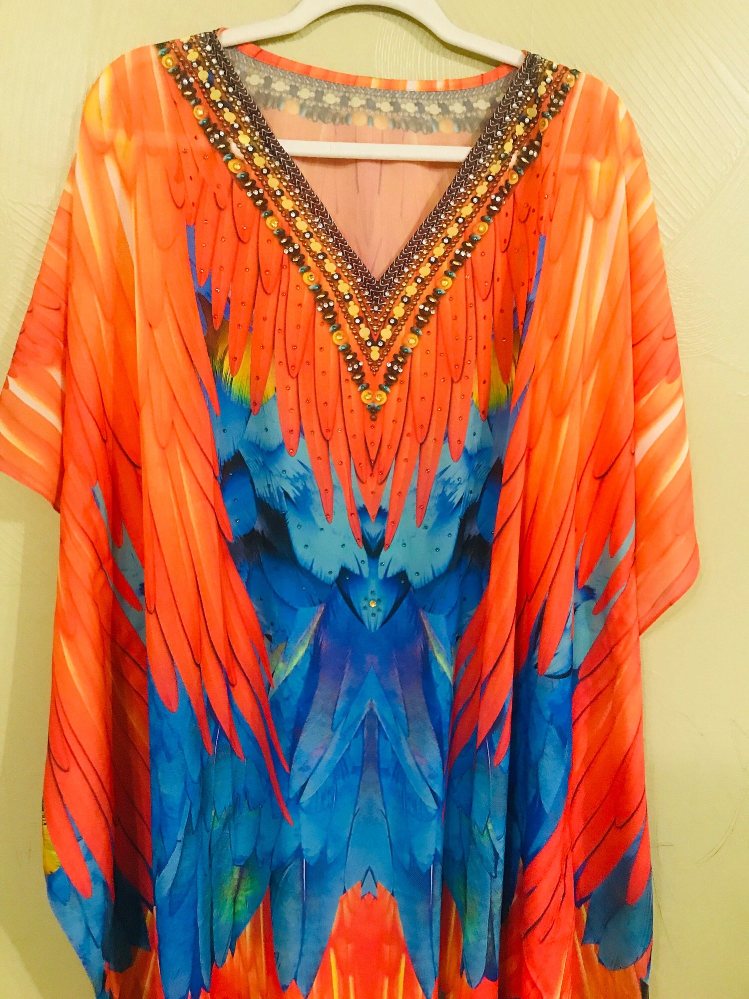 Plus size tribal feather kaftan dress by Erin Pontus, flowing bohemian style with intricate patterns and vibrant fabric details.