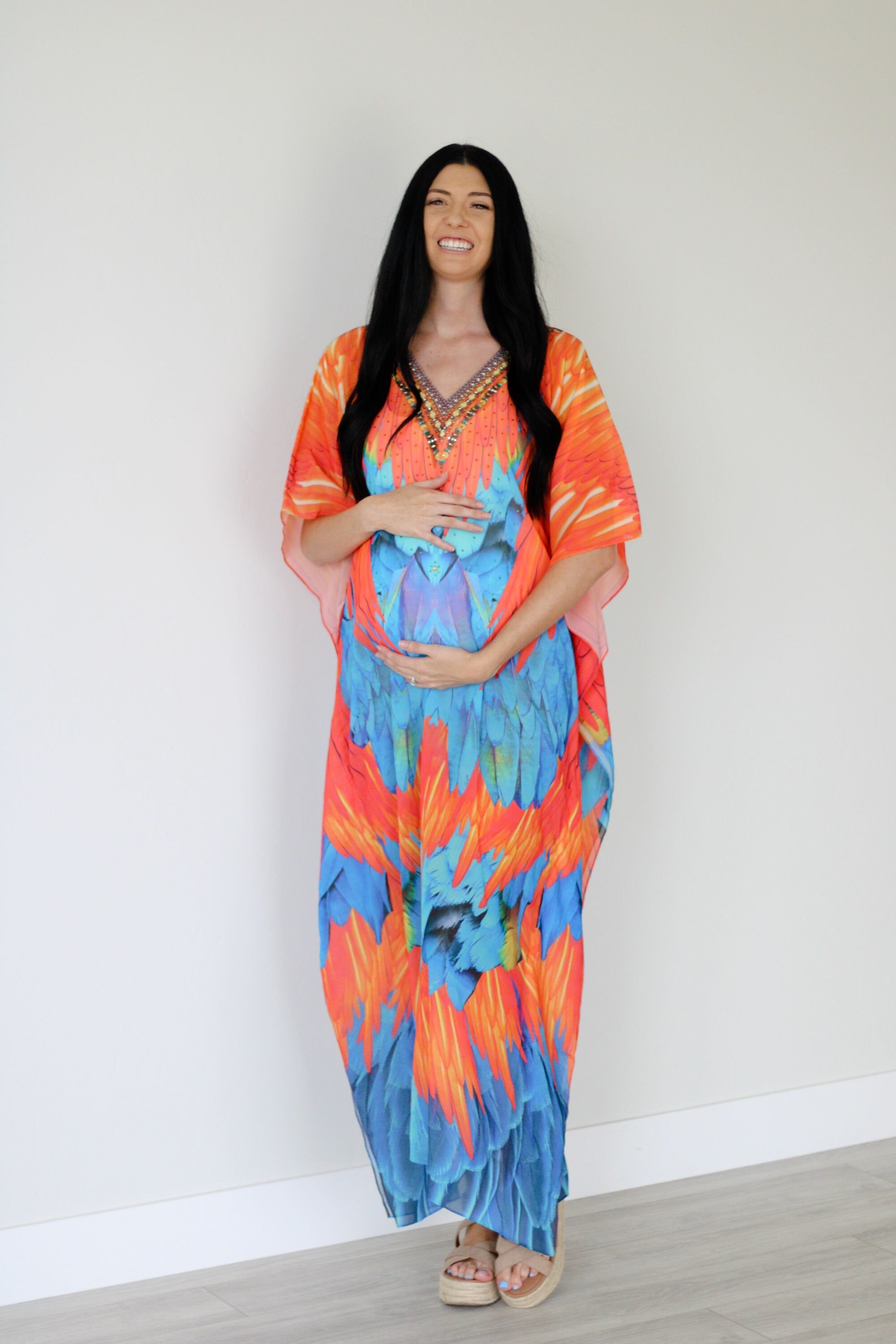 Plus size tribal feather kaftan dress by Erin Pontus featuring vibrant patterns and flowing fabric for women.