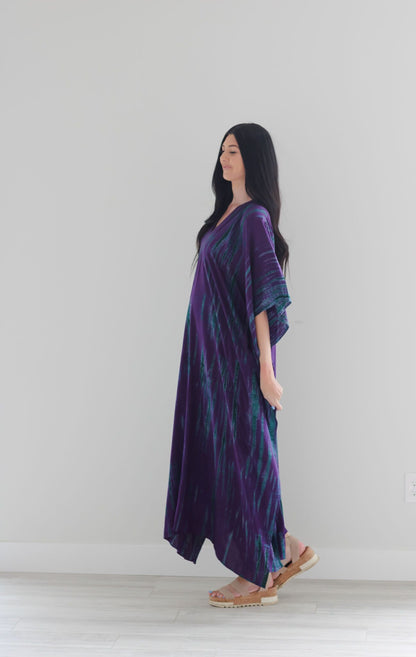 Purple tie-dyed maxi kaftan dress by Erin Pontus featuring a flowy, relaxed fit with vibrant purple and blue hues.