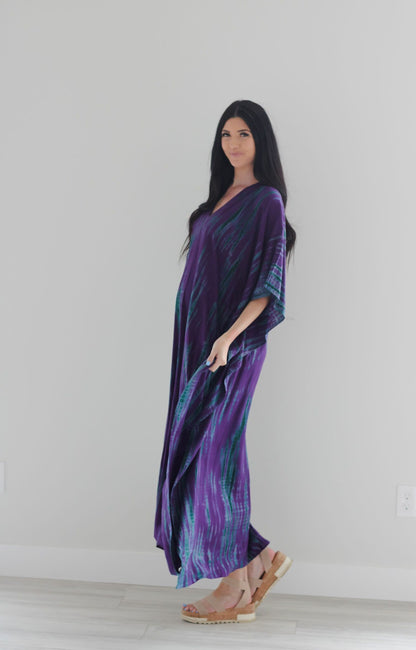 Purple tie-dyed maxi kaftan dress by Erin Pontus, flowing fabric with vibrant purple and blue patterns, perfect for elegant occasions.