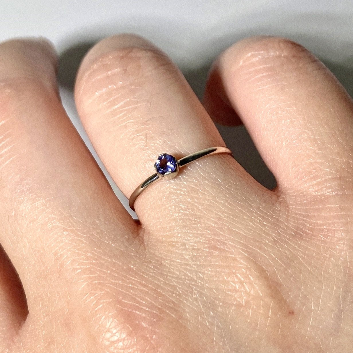 Sterling silver dainty ring featuring a solitaire iolite gemstone, showcasing elegant jewelry design by Grey Clymene.