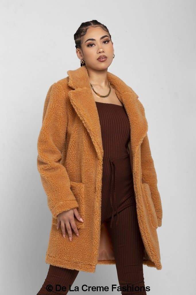 Rose Eleusis Jacqueline oversized teddy coat draped on a hanger, showcasing plush beige fabric and cozy, oversized fit.