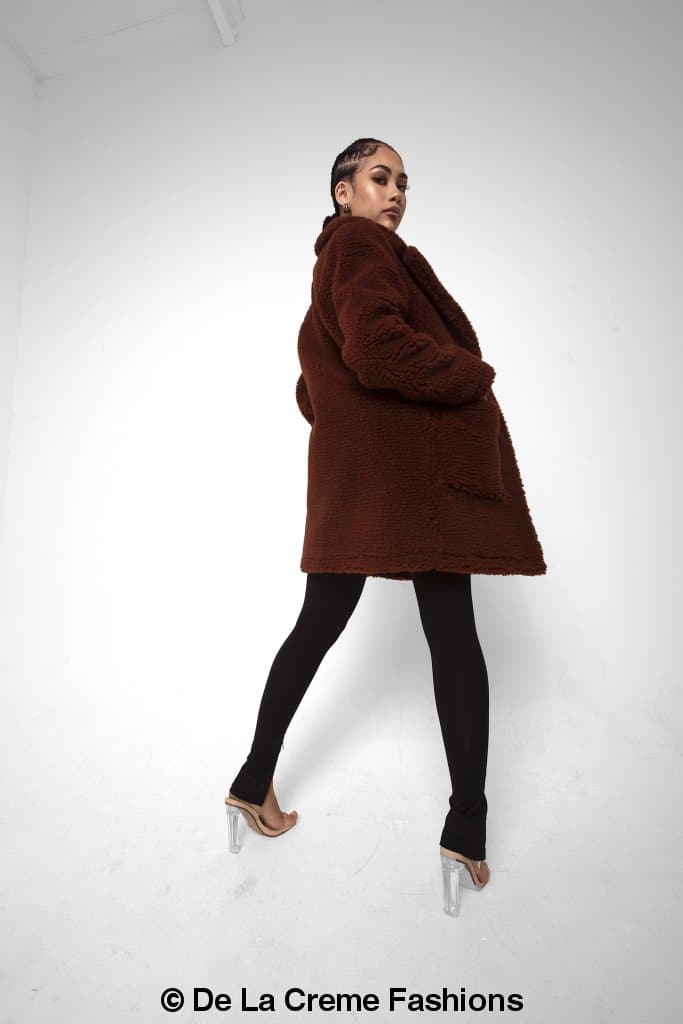 Rose Eleusis Jacqueline oversized teddy coat hanging on a rack, showcasing plush fabric and cozy winter jacket style.