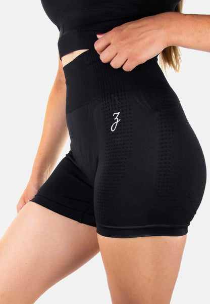 Black Damen Shorts by Pear Juniper, featuring a sleek design and comfortable fit, shown from a side view.