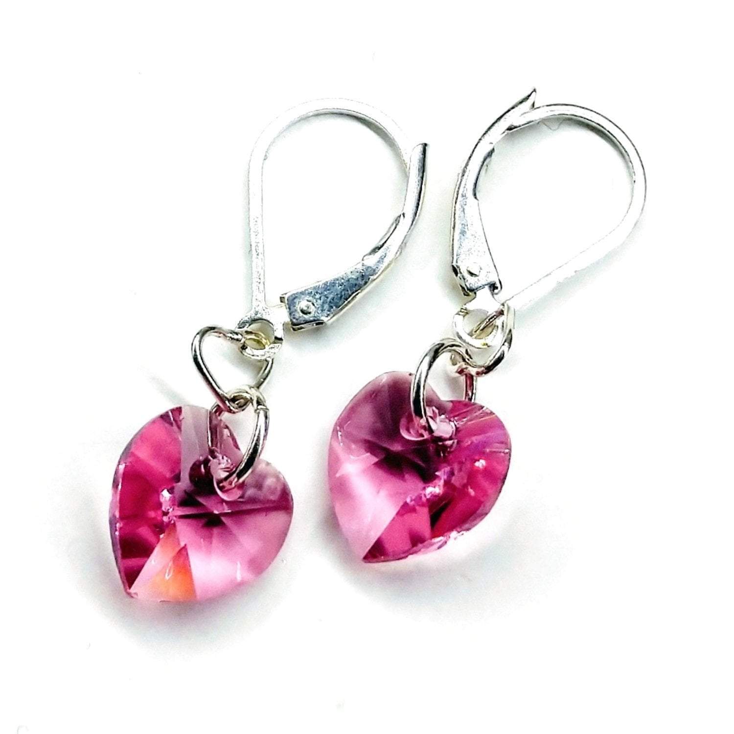 Sterling silver pink crystal heart earrings by Blue Crius, featuring delicate heart-shaped pink crystals on elegant silver hooks.