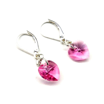 Sterling silver pink crystal heart earrings by Blue Crius, featuring delicate heart-shaped pink crystals and polished silver hooks.