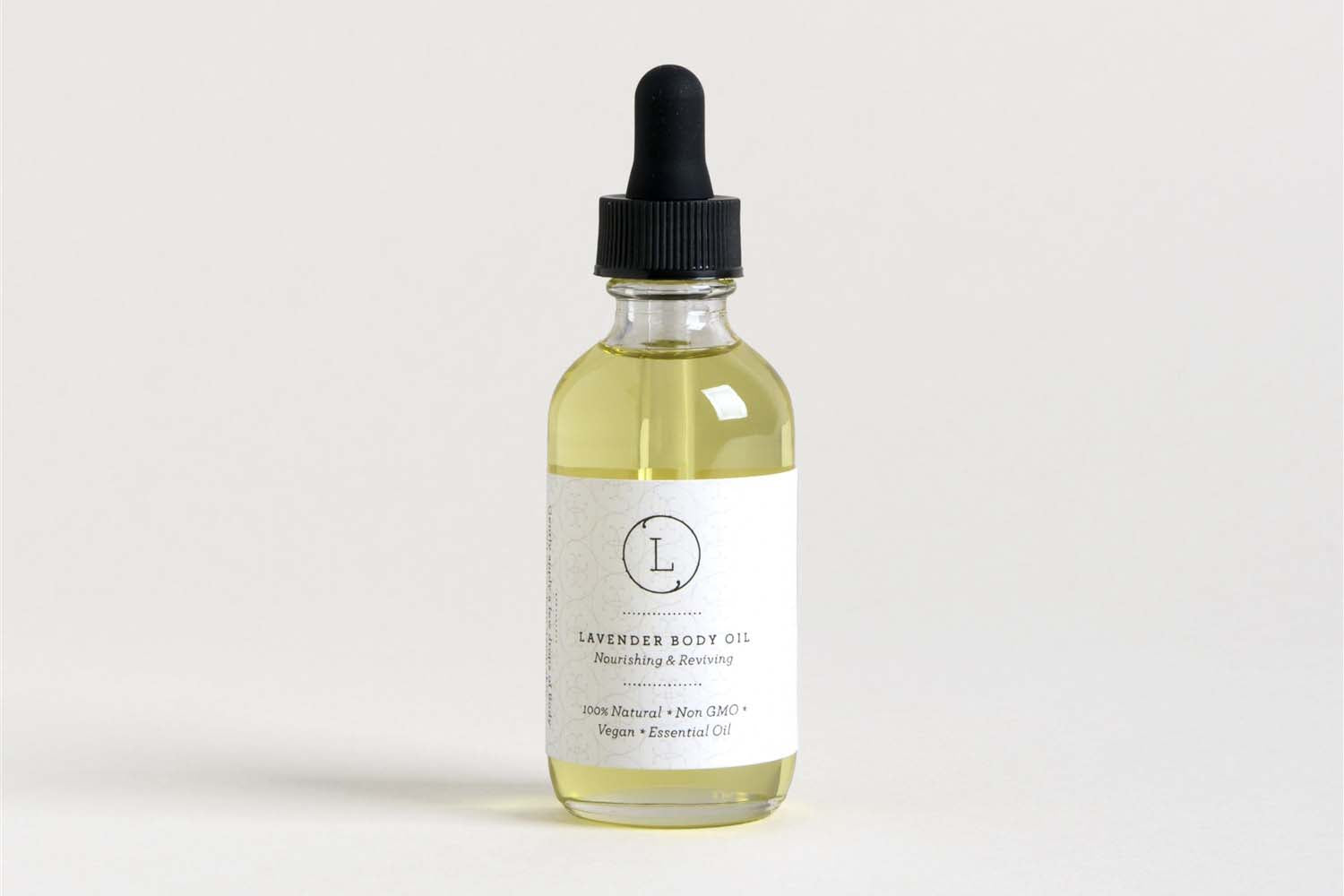 Start2Finish lavender natural body oil bottle with a clear label, placed on a white surface with soft natural lighting.