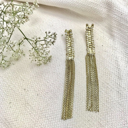Long gold tassel earrings by Ariel featuring elegant, flowing tassels, perfect for statement jewelry and stylish outfits.