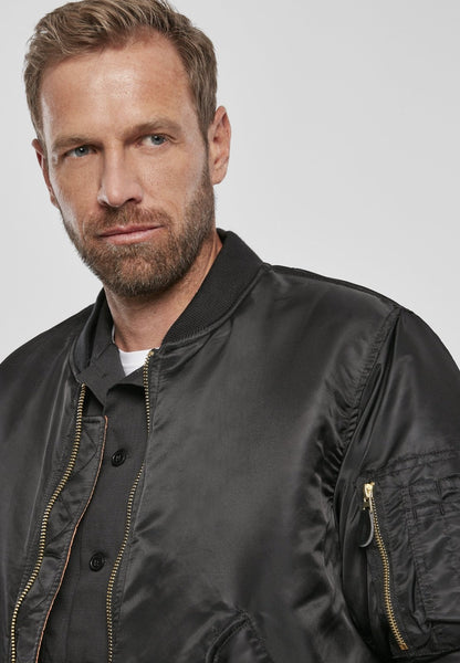 Callisto MA1 bomber jacket in black, featuring ribbed cuffs and collar, displayed on a hanger against a neutral background.