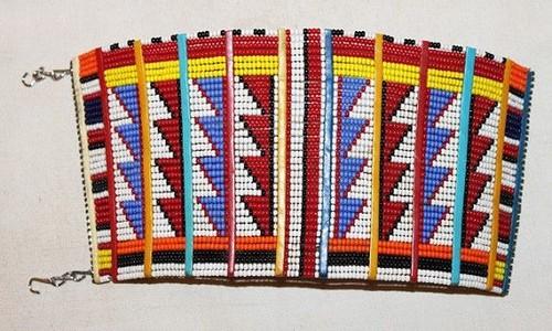 Colorful Maasai beaded traditional bracelet by White Baobab featuring vibrant ethnic beadwork on a woven band.