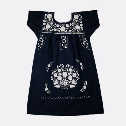 Navy blue boho chic dress with white floral pattern for women, styled by Violet Athena, hanging on a clothing rack.