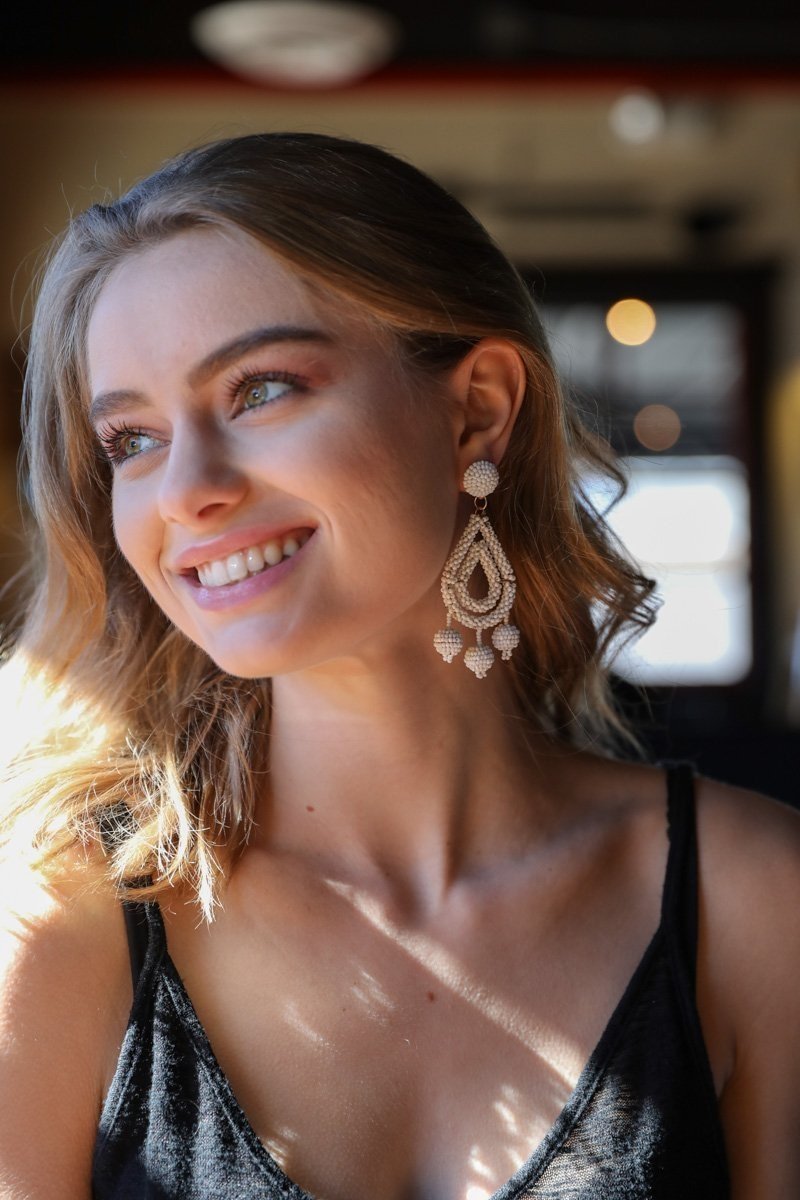 White micro bead dangle earrings from Periwinkle Aether, featuring delicate hanging design perfect for accessories and fashion.