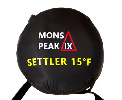Triangulum Settler 15F sleeping bag in stuff sack, ideal for camping and outdoor adventures.