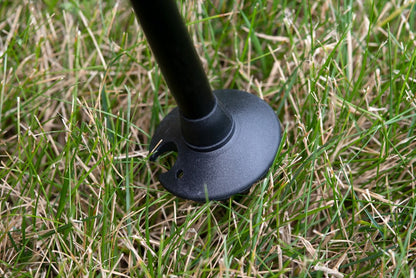 Triangulum trekking poles with 50mm mud and snow baskets, shown in grass, designed for hiking and outdoor camping activities.