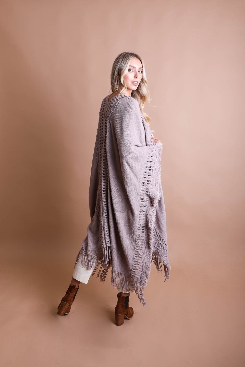 Open work bohemian ruana with frayed edges, stylish accessories by Periwinkle Aether, showing the relaxed, layered fabric design.