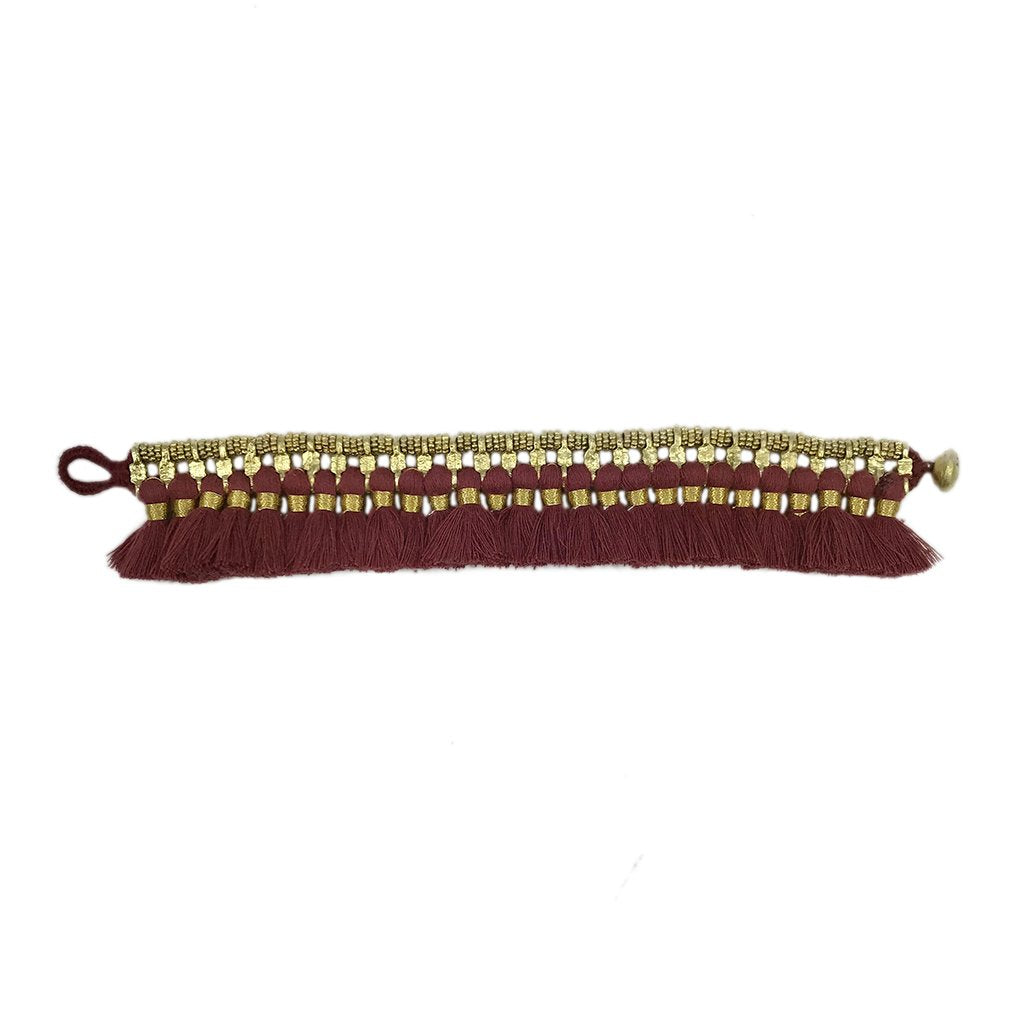 Red tassel cuff bracelet by Ariel featuring vibrant tassels and intricate design, stylish accessory for casual or boho outfits.