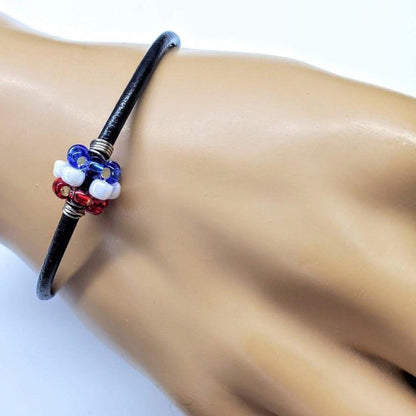 Red, white, and blue beaded leather bracelet by Blue Crius, featuring patriotic design and adjustable strap.