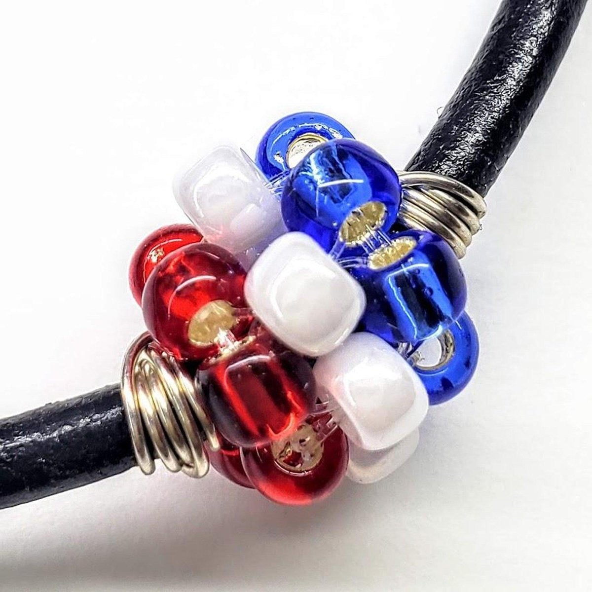 Red, white, and blue beaded leather bracelet by Blue Crius, featuring patriotic design and adjustable closure.