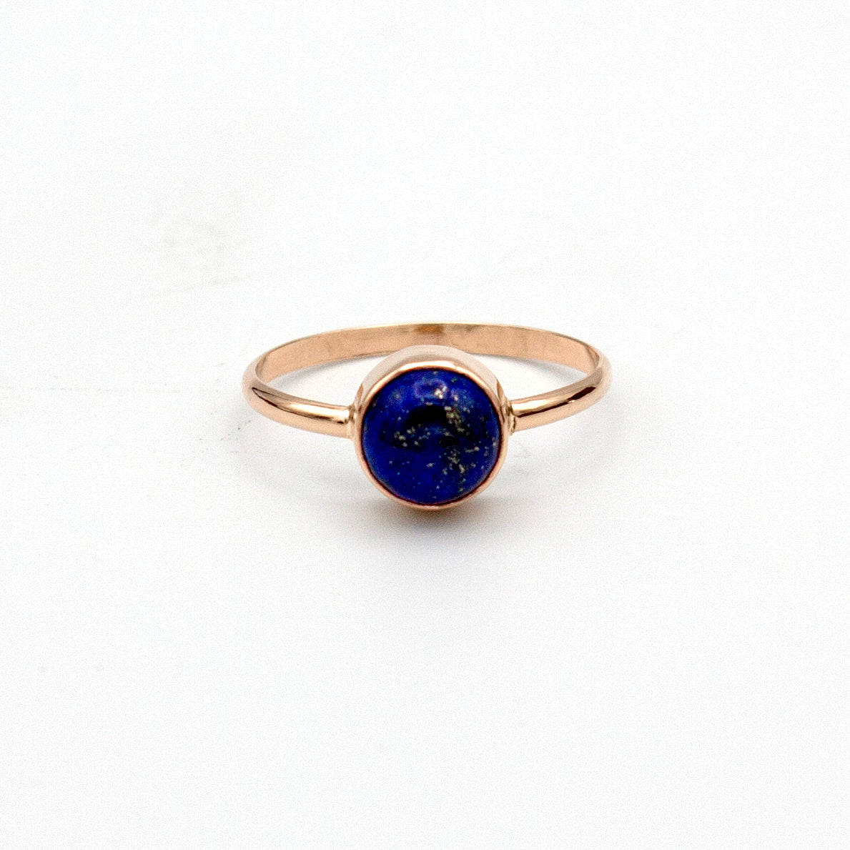 Gold-filled ring with a round bezel setting featuring a deep blue lapis lazuli gemstone, crafted by Grey Clymene.